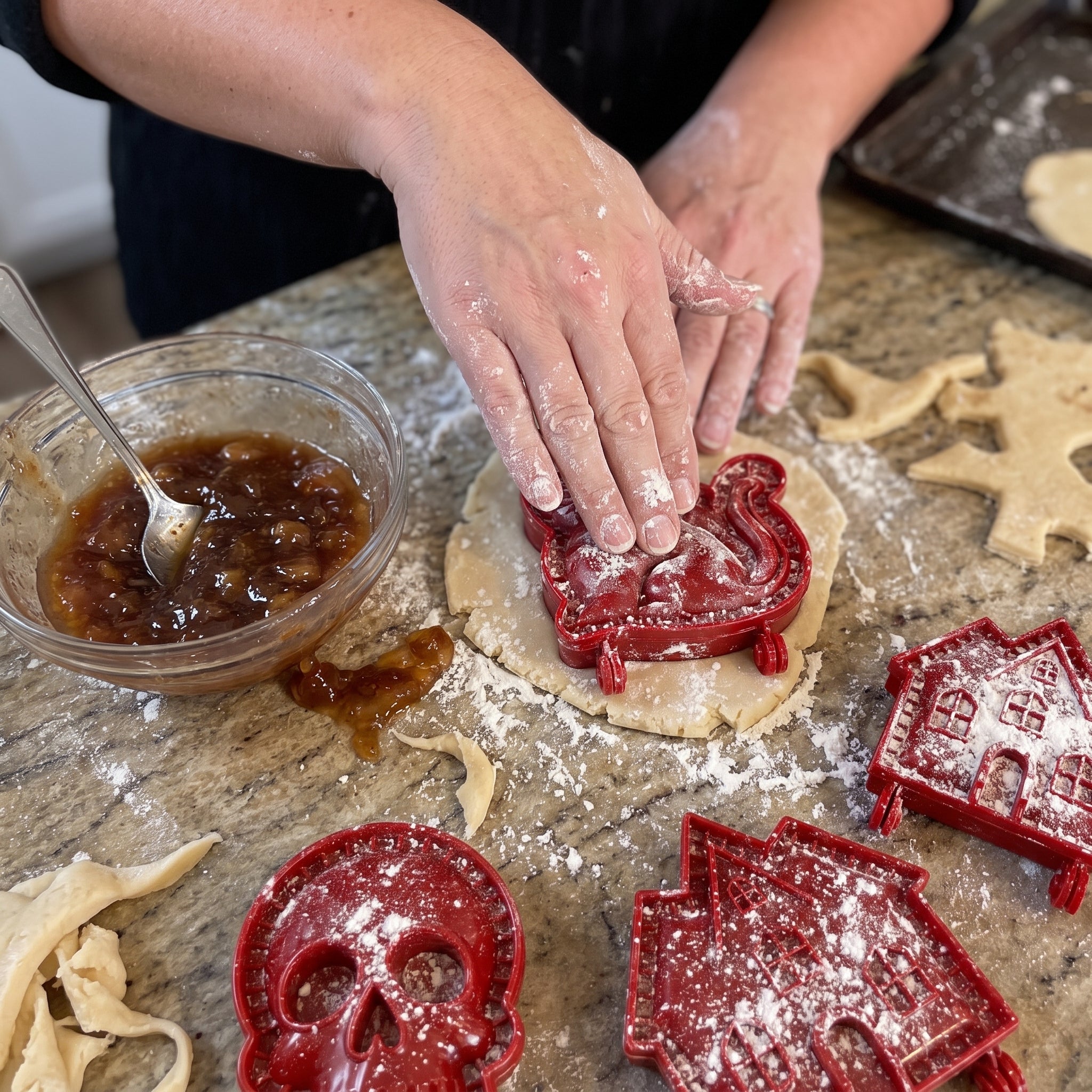 Hands pressing a Halloween hand pie mold into dough